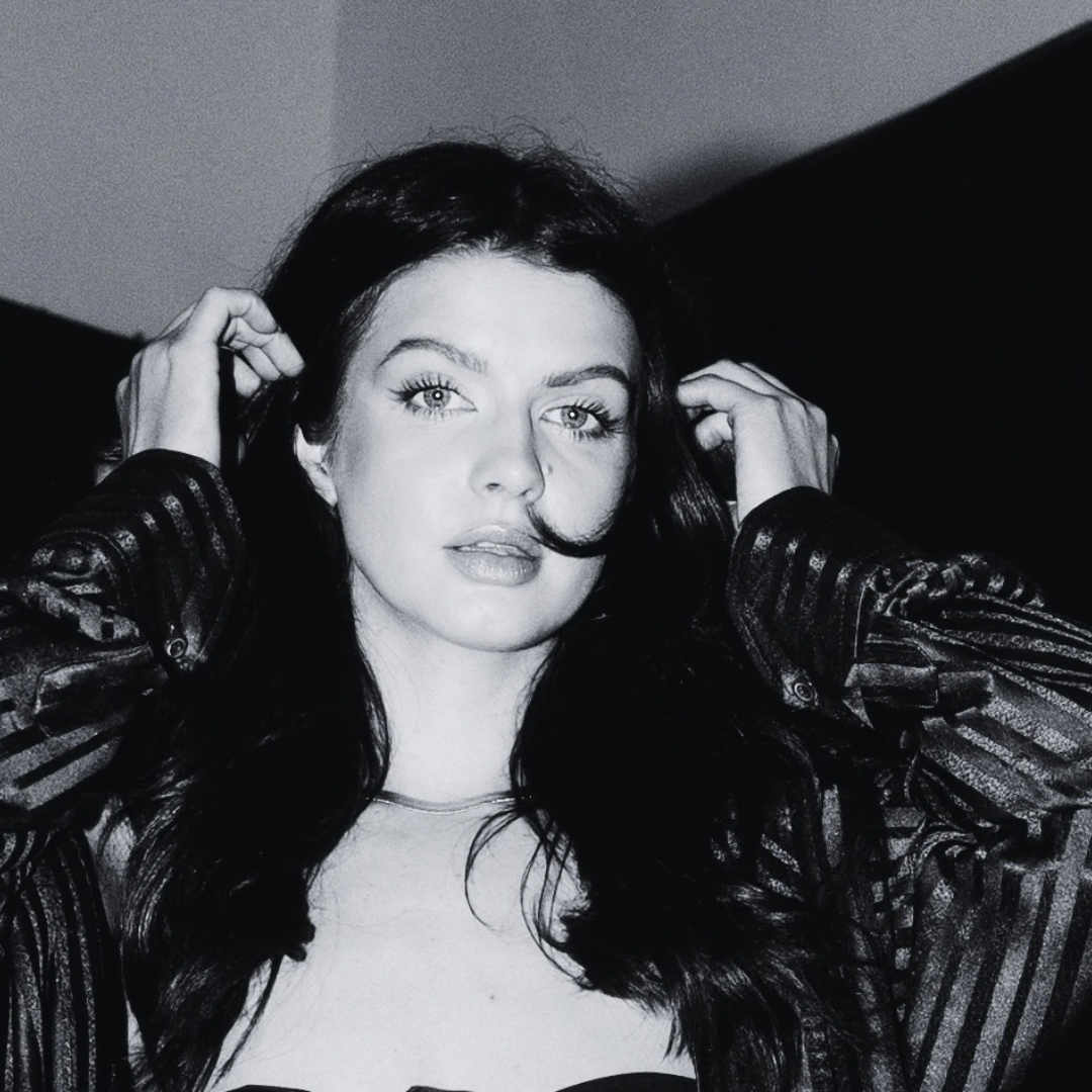 Black and white portrait of a model in a leather jacket, hair and makeup by Nicole D.